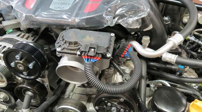 126. Connect the throttle body extension harness to the throttle body connector and