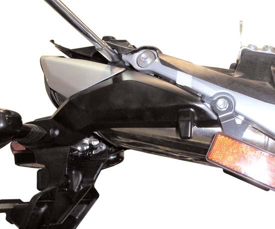 13)The center (tail light) section of the rear fender will now separate from the arms. It will not be reused.