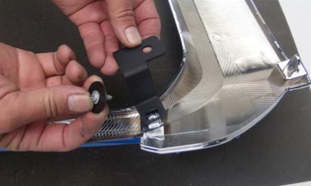 Take the two Z support brackets and install them on backside of the factory grille shell with the arm bending downward as shown (picture 29).