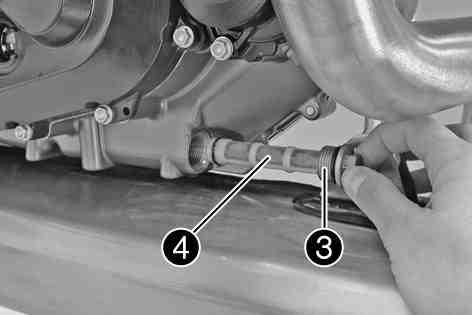 Place a suitable container under the engine. Remove plug with oil screen and the O-rings.