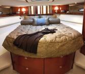 The custom-designed master stateroom features a full-size bed with innerspring mattress, two full-length hanging lockers, and a 20" LCD flatscreen TV with remote DVD