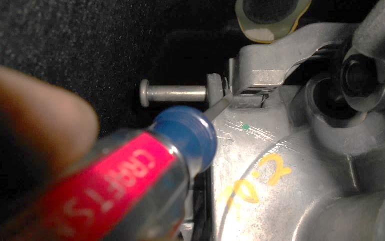 Remove the spring loaded clip from the cross pin that attaches the shift rod to the