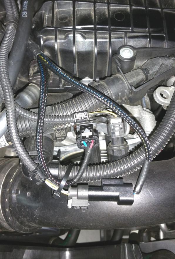3. Remove the engine cover by pulling upward. 4. Referring to the photo below, identify the pressure sensor mounted to the intake charge pipe, at the front of the engine.