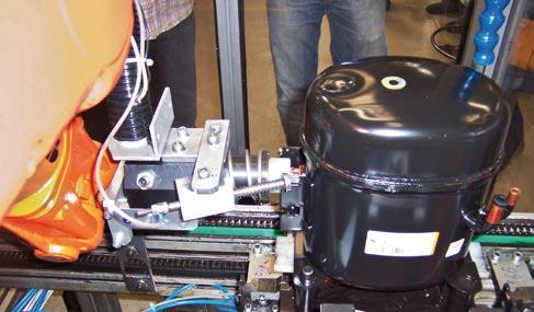 1 3 2 1 Robot IRB 140 na prvom robotizovanom stanovišti plní olejovú zmes do kompresora. 2 Druhý takýto robot kontroluje funkčnosť elektrických obvodov kompresora.