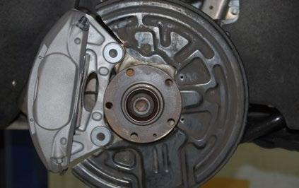 If the brake shield will need trimmed, mark it, remove it from the car and trim it as required.