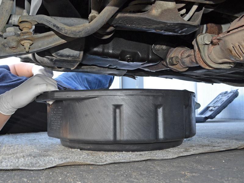 Use a 17 mm socket wrench or box end wrench to turn the oil drain plug counter-clockwise until it is loose enough