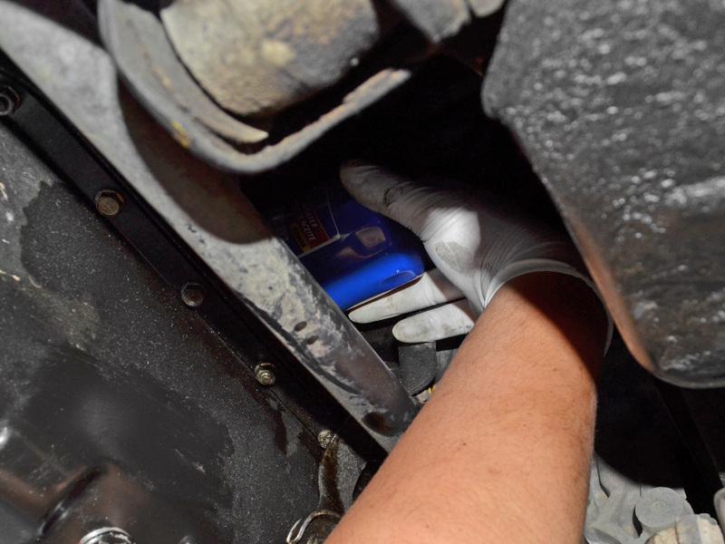 Guide the oil filter back over the engine's oil filter threads and turn the filter clockwise until it is snug.