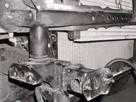 Position a hydraulic floor jack and a wood block under passenger side of cab (under the body seam).