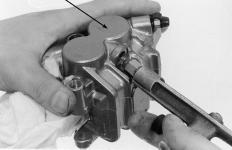 Remove te brake caliper bracket bolts, ten remove te brake caliper and bracket as an assembly.