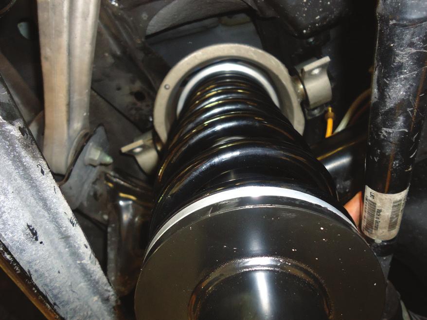INSTALL THE NEW REAR COIL SPRING STRUT IN THE TOP MOUNT AND SECURE WITH