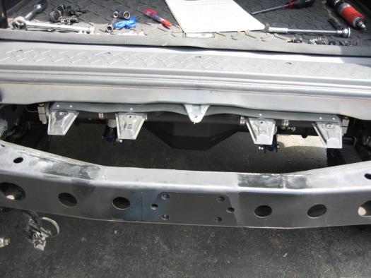10.) Use a 10mm socket to remove the 4 brackets from underneath the rear