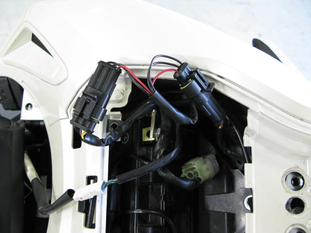 3. In the tail section, remove the small black panel to gain access to the tail light connector.