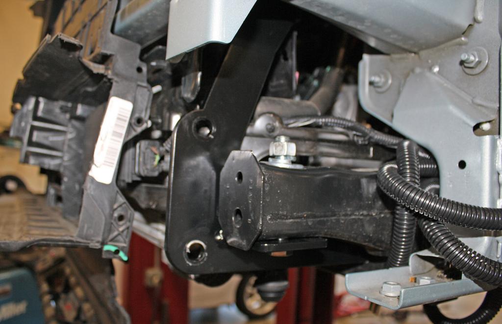 On each side, place one of the supplied ½" plate washers over a ½" x 5½" bolt and bolt through the bumper core and rear brace and finish