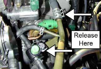 g. Release the spring clamp on the breather hose attached to the valve cover.
