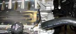 53. Using a razor blade or equivalent, remove the rubber guard on the factory coolant crossover and install it onto the supplied coolant crossover. 54.