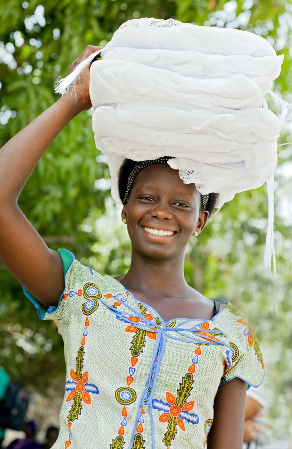 July 2013 SENEGAL A woman in Senegal carries the mosquito nets she received from the National Malaria Control Programme's (NMCP) Universal Coverage campaign with NetWorks Senegal.