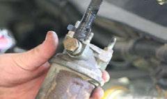 D. With the 10mm tool of your choice, remove the three nuts on the top of the bracket that holds the fuel pump in place.