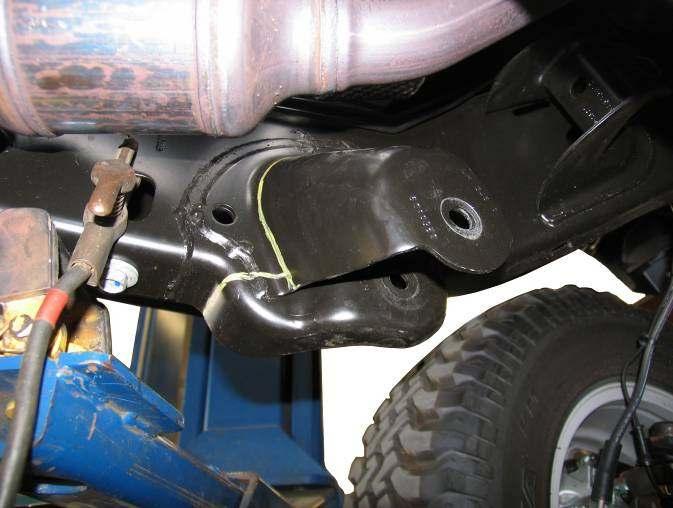 CAUTION: Do not allow the front axle to hang by any hoses or cables. SUSPENSION ARM REPLACEMENT 1) Support the front axle with a jack.