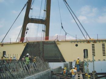 the back span Lifting of a segment of the main span from barge Placing the first segment onto the deck