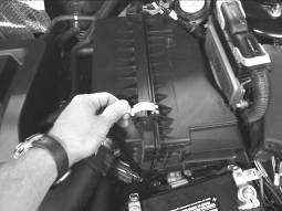 10. Disengage the metal fasteners on the air filter box cover and move the cover to one side