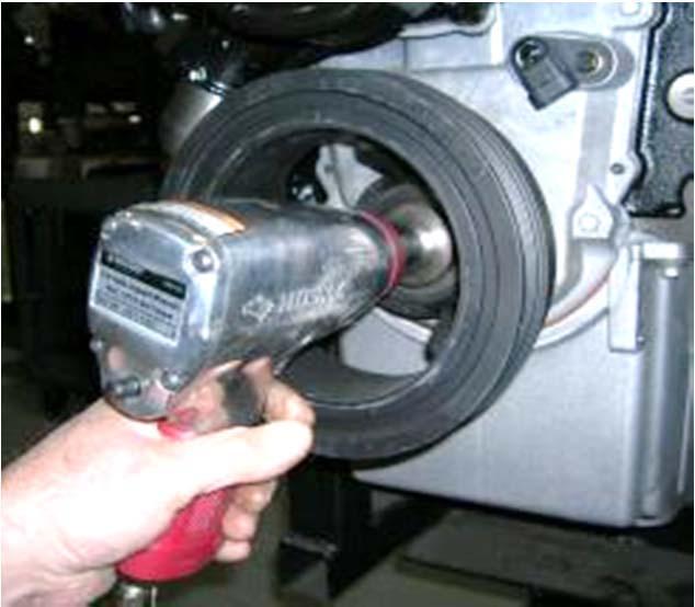 7. Using impact wrench, remove crankshaft pulley bolt and washer from crankshaft nose. 8.
