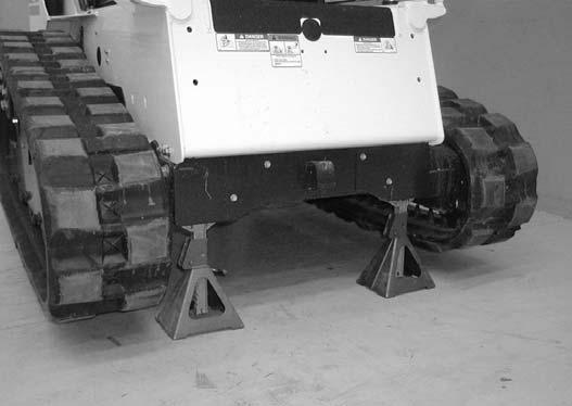 Put floor jack under the rear of the loader [Figure 10-10- 2]. Lift the rear of the loader and install jackstands [Figure 10-10-2].