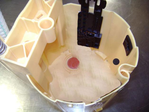 With the pump and screen filter removed, a small orange/red rubber valve can be seen on the bottom of the fuel tank module.