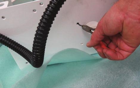 Use side cutters to remove the black wire tie from the underside of the