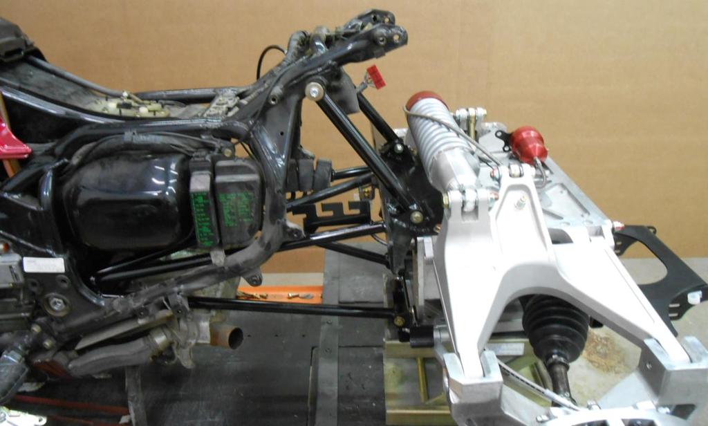 Rear Suspension Unit Installation: 1. Place the rear suspension unit onto a flat jack. 2. Slide rear suspension unit forward behind prepared motorcycle frame. 3. Moving the rear end forward.