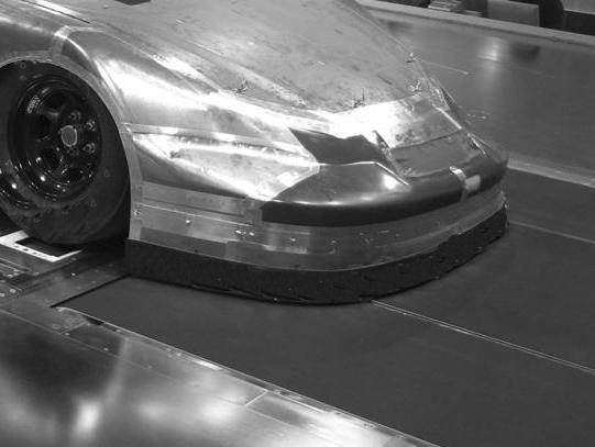 front wing of a racing car; ahead of the front wheels.