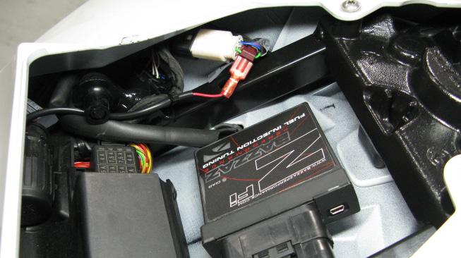The servo motor for the velocity stacks, located to the left of the ECU, may need to be removed in order to unplug.