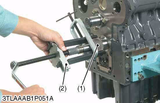 W1025309 Oil Pump 1. Remove the nut. 2. Draw out the oil pump drive gear (1) with gear puller (2). 3.