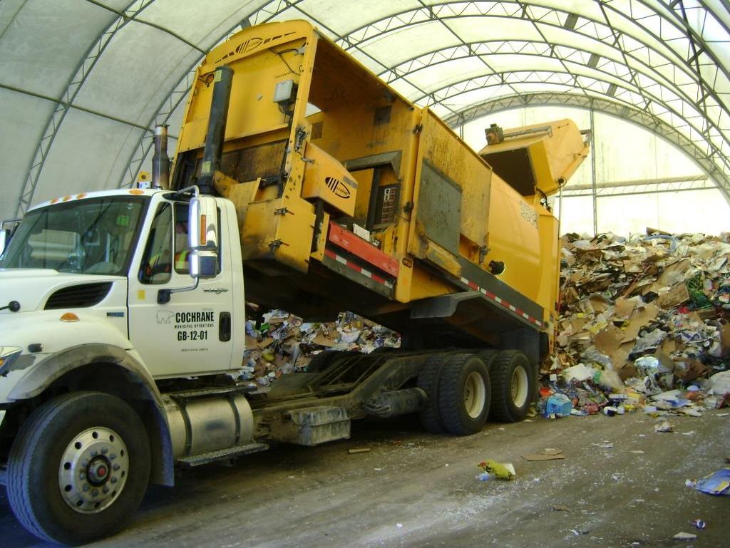 Figure 8: Collection vehicle dropping a load of recyclable material at the Town TS Traditional transfer station costs are in the range of $1-2M for a 2,500 tonne per year facility, instead the Town s