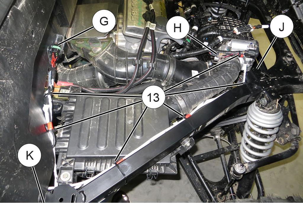 8. Install camera harness. a. Ensure engine is COLD, then lay rear portion of camera harness d across top of engine.