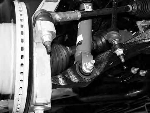 FIGURE 4 24. Remove the upper and lower ball joint nuts. Reinstall the nuts a few turns by hand. Separate the upper and lower ball joints from the steering knuckle using the appropriate puller.