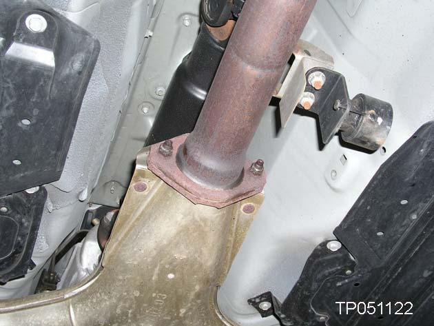 11. Remove and discard the exhaust system center tube front nuts (see