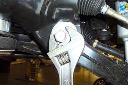 control arm and the bottom coil of the spring, to draw the lower control arm closer to the
