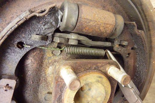 inward on the brake shoe hold down spring and