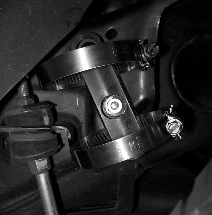 F. Install the 8mm split washer on to the M8 screw. G. With the tab on the threaded stud facing toward the front of the vehicle, hook the tab into the lower oval hole.