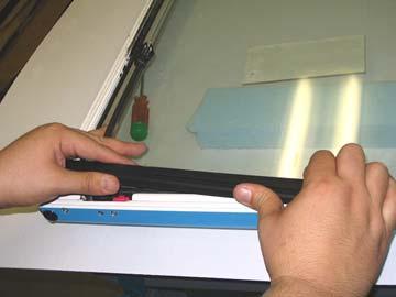 Perform the following tasks with extreme caution to avoid damaging the fastener socket-head, as well as the door glass. a. Using a power drill with 5/16 drill bit, carefully insert the bit into the access hole of the door rail.