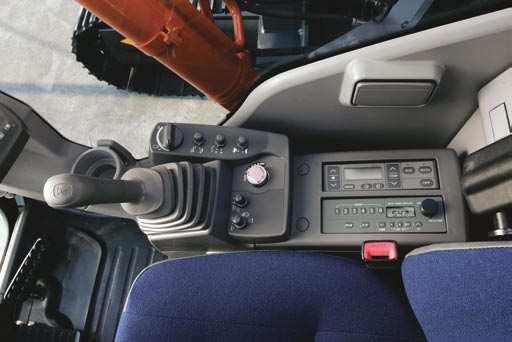 HITACHI logo. Wide adjustable armrests and a retractable seat belt are included.