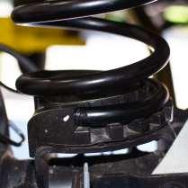 L. Slip the bottom of the coil onto the coil base on the axle.