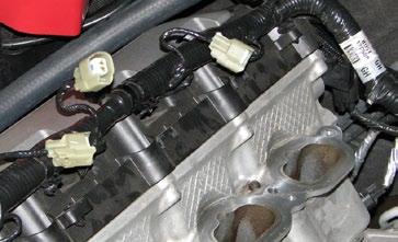 65. Clip the supplied fuel crossover hose onto the 180 shaped fittings installed in the center of each rail. 66. Cover the injector bores with tape to prevent debris from entering the bores.