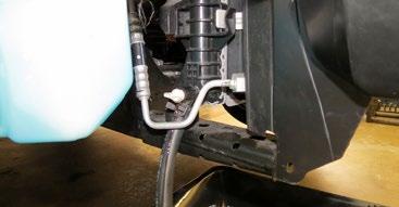 Remove the front strut tower brace (if equipped) using a 15mm socket.