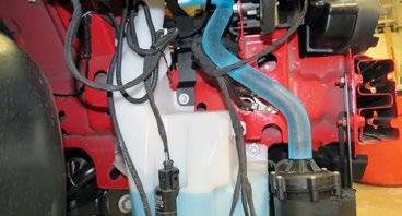 98. Connect the Water pump to Surge tank hose to the water pump and secure with a