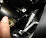 Loosen the 2 nuts holding in the power steering