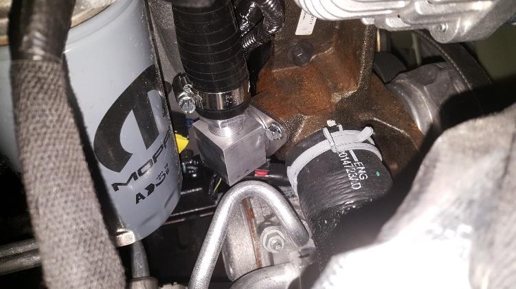The coolant adapter block should be connected to the coolant port on the front of the engine block.
