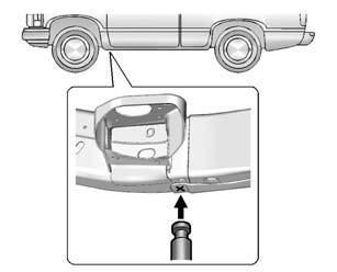 Position the jack on the frame behind the flat tire where the frame sections overlap. Turn the wheel wrench clockwise to raise the vehicle.