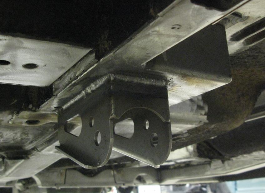 d. Insert a 7/16 bolt through the smaller hole in the lower link bracket and through the original front leaf spring bracket bolt hole to locate the fore/aft position of the brackets.