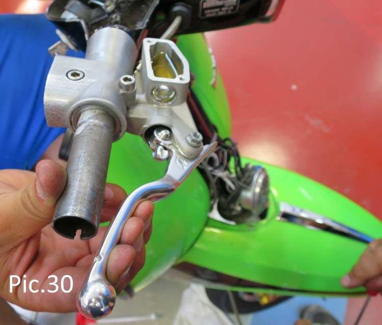 Holding in the lever to the handlebars, slowly unscrew the air bleed screw (this is easiest done by two people) allowing it to release